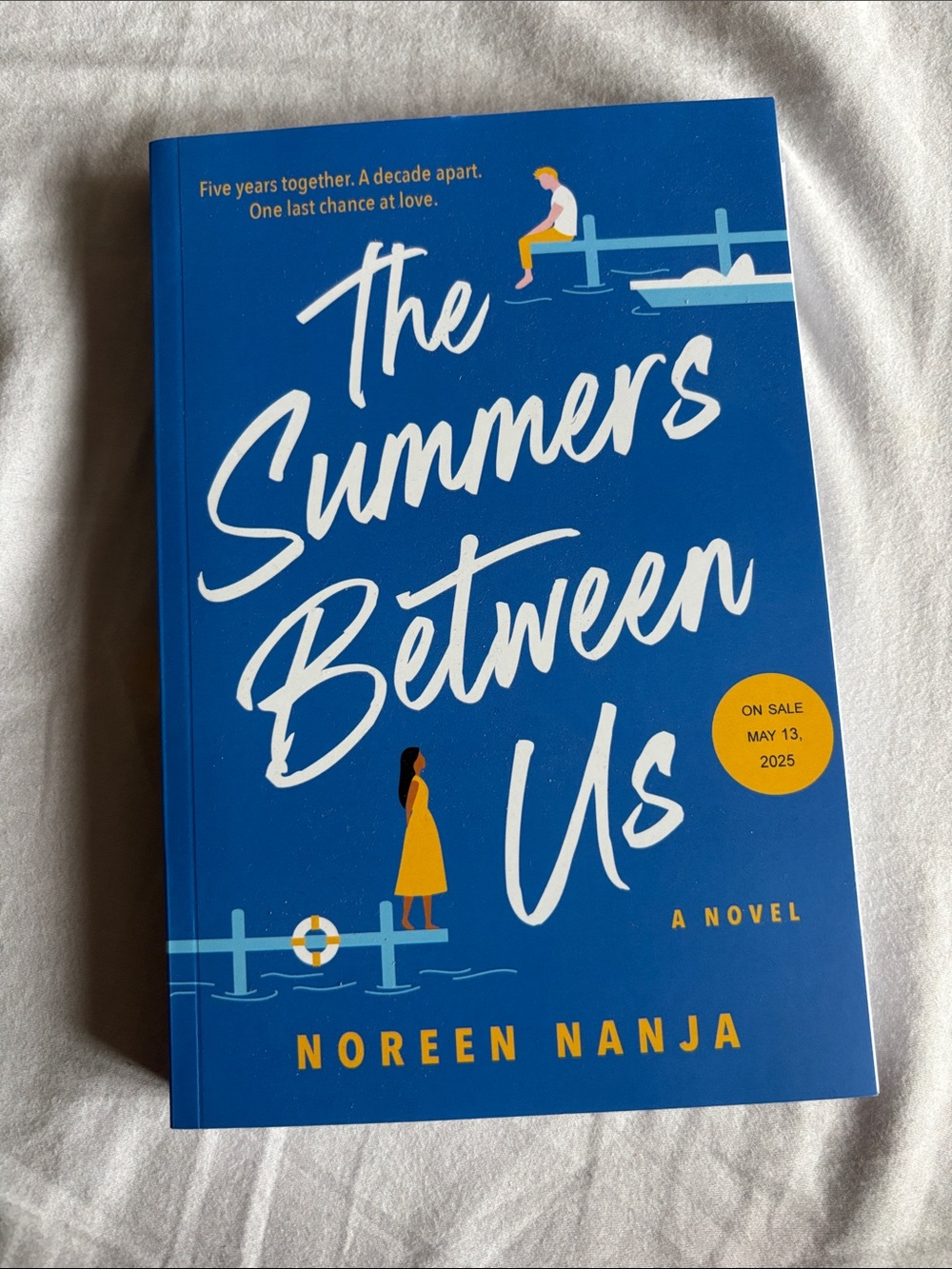 The Summers Between Us by Noreen Nanja — Blue Paperback Novel